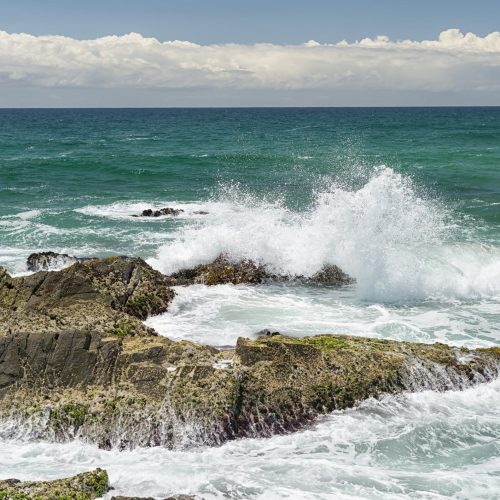 Australia, New South Wales, Byron Bay, Broken Head nature reserve, waves breaking on rocks and clouds over the sea